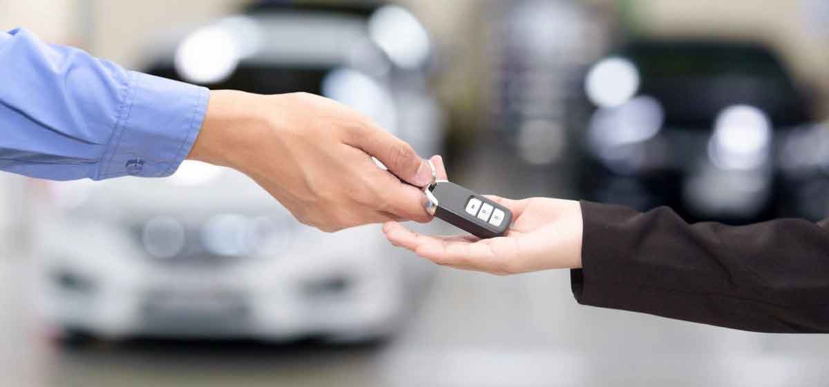 Car saleswoman handing over new car keys
